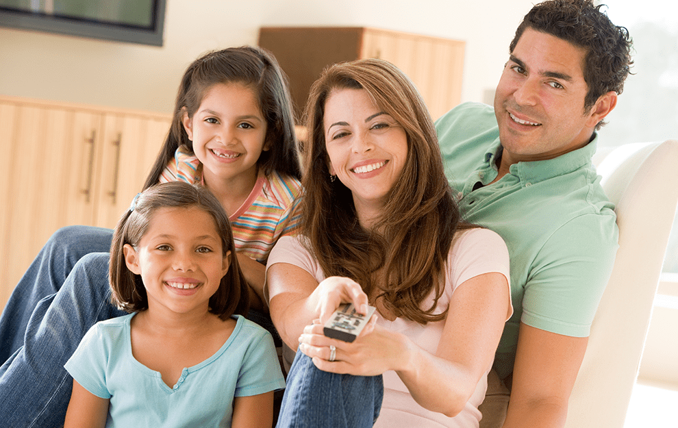 Happy family watching TV together in the living room.