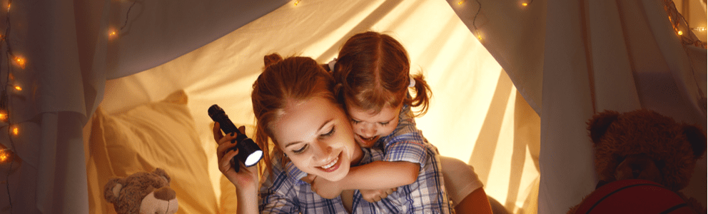 A joyful child hugging a smiling woman warmly.